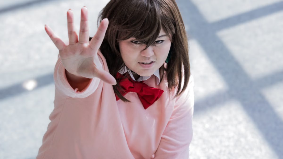 Young adult in anime-inspired cosplay, energetically posing indoors.
